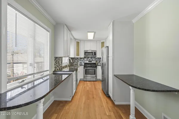 a kitchen with granite countertop a stove top oven and sink