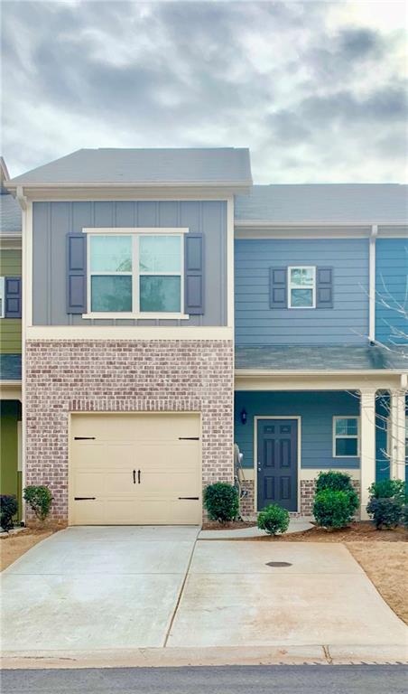 183 Spring Way Square Canton, GA 30114 - Photo 2 of 29 a front view of a house with a yard and garage
