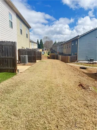 a swimming pool with yard and wooden fence