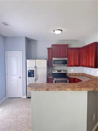 a kitchen with stainless steel appliances granite countertop a refrigerator sink and stove