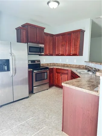 a kitchen with a sink a stove and a refrigerator