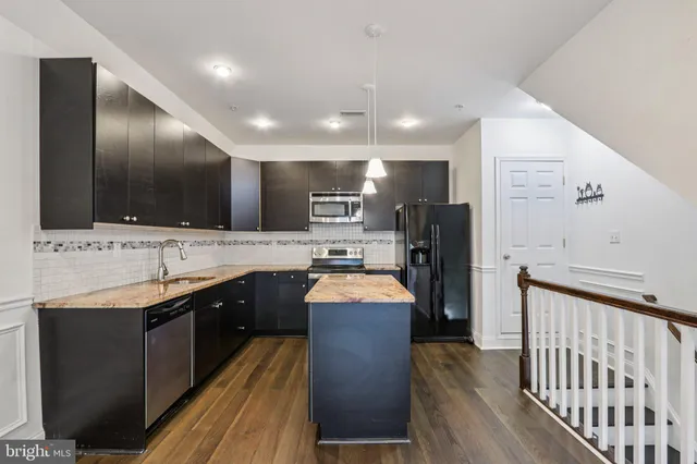 a large kitchen with kitchen island a sink stainless steel appliances and cabinets