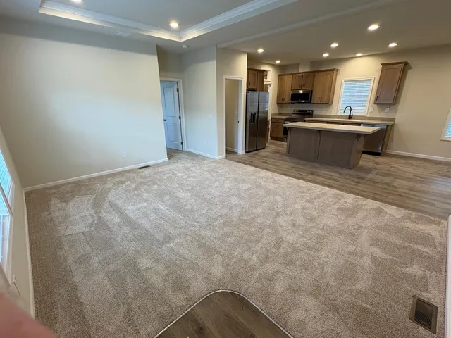 a view of kitchen with kitchen island stainless steel appliances refrigerator sink and stove