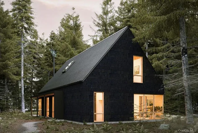 a front view of a house with large trees