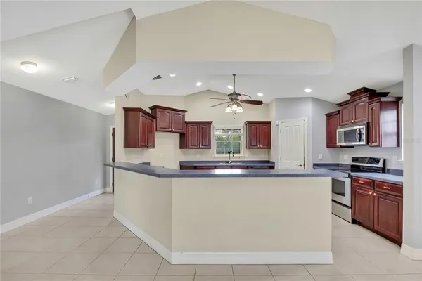 a kitchen with stainless steel appliances granite countertop a sink a stove and a microwave