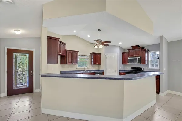 a large kitchen with stainless steel appliances granite countertop a sink and cabinets