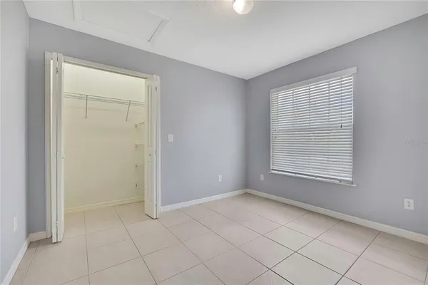 a view of an empty room with window and a bathroom