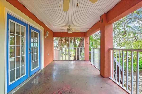 an empty room with windows and ceiling fan