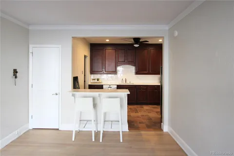 a kitchen with granite countertop white cabinets and refrigerator