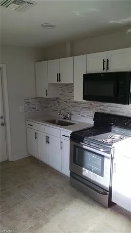 a kitchen with granite countertop a stove and a microwave