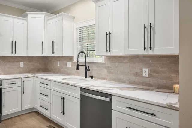 a bathroom with a white tub a toilet and a window
