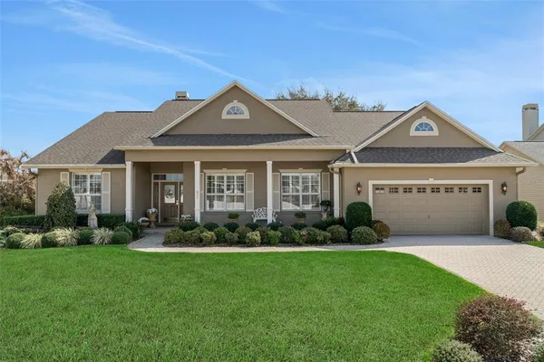 a front view of a house with a garden and plants