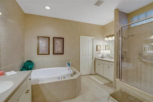 a bathroom with a granite countertop sink a mirror a bathtub and shower