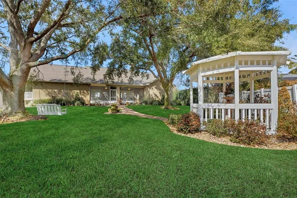 a view of a house with backyard and a tree