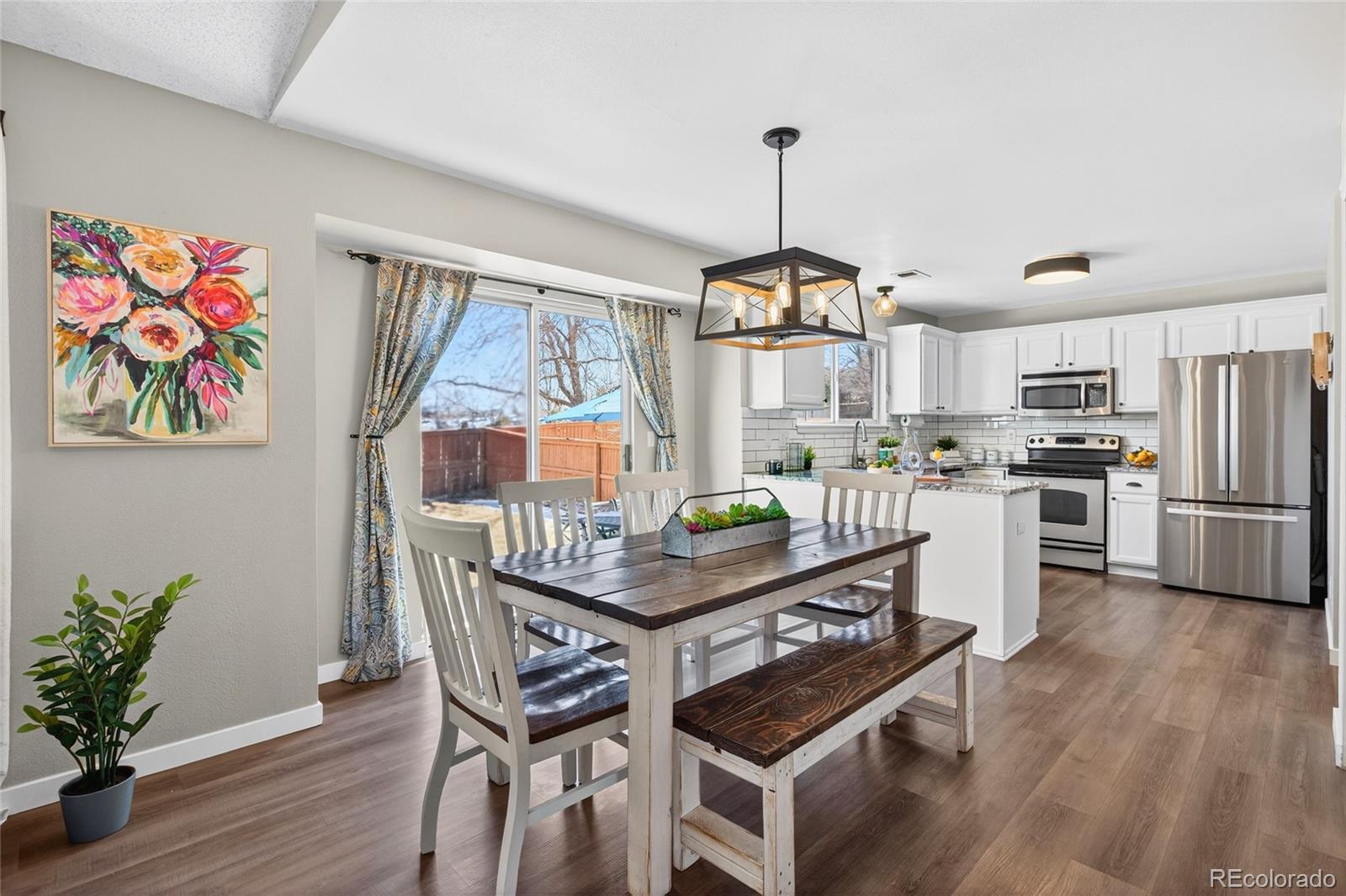 9600 South Castle Ridge Circle Highlands Ranch, CO 80129 - Photo 13 of 50 a kitchen with stainless steel appliances granite countertop a stove top oven a refrigerator and wooden floor