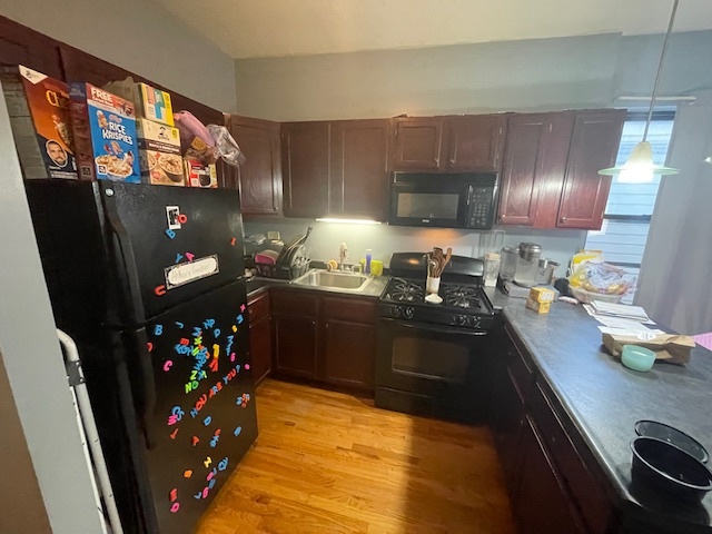 2620 West 24th Street Chicago, IL 60608 - Photo 6 of 25 a kitchen with granite countertop a refrigerator stove and wooden floor