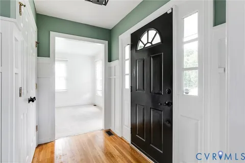a view of a hallway with wooden floor and closet