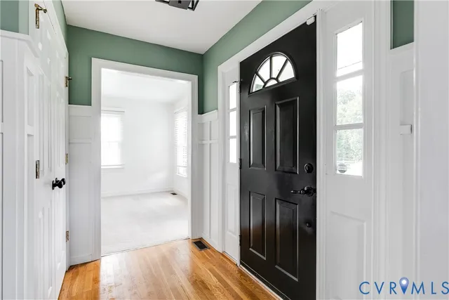 a view of a hallway with wooden floor and closet