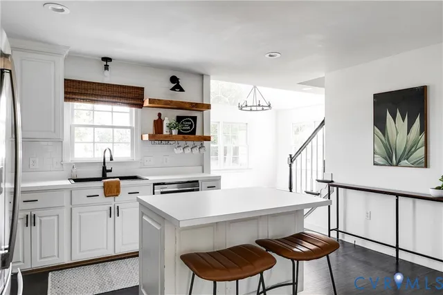 a kitchen with a cabinets a sink and chairs