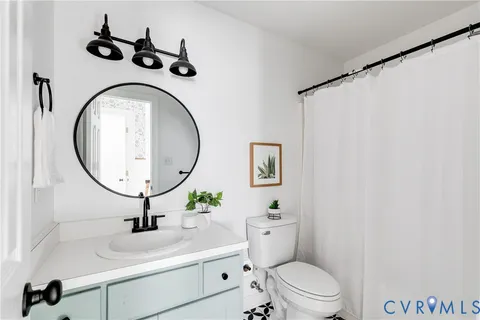 a bathroom with a toilet sink vanity and mirror