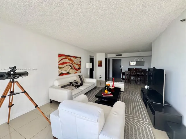 a living room with furniture and a dining table