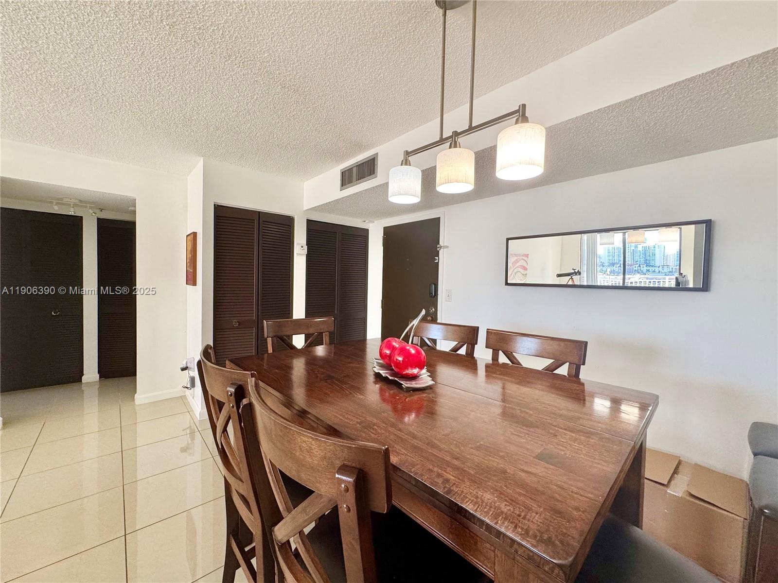 210 174th Street, Unit 1002 Sunny Isles Beach, FL 33160 - Photo 14 of 34 a view of a dining room with furniture and chandelier