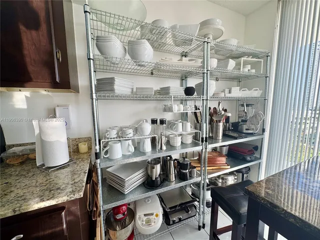 a kitchen with stainless steel appliances kitchen island granite countertop a sink refrigerator and cabinets