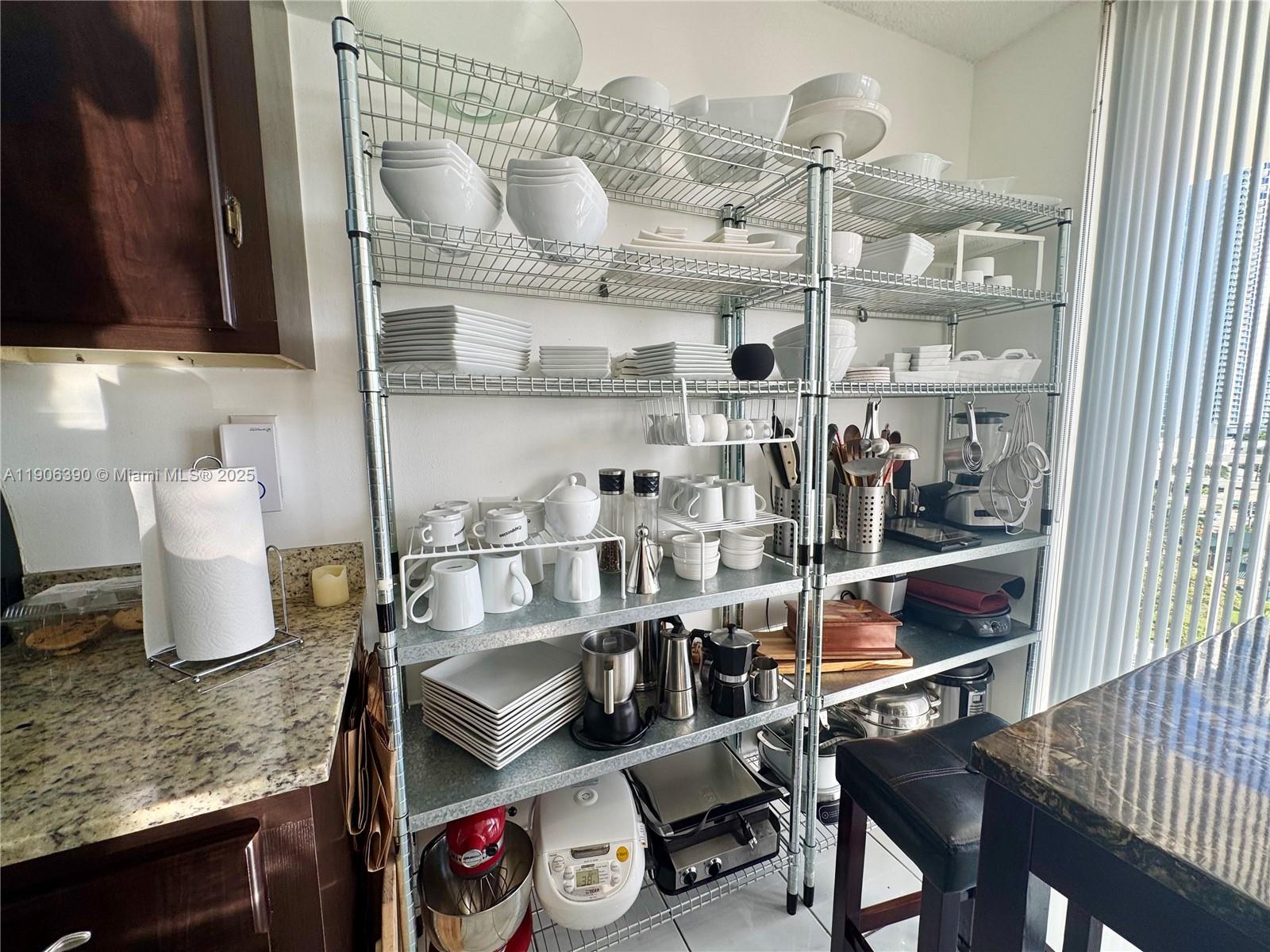 210 174th Street, Unit 1002 Sunny Isles Beach, FL 33160 - Photo 17 of 34 a kitchen with a refrigerator and cabinets