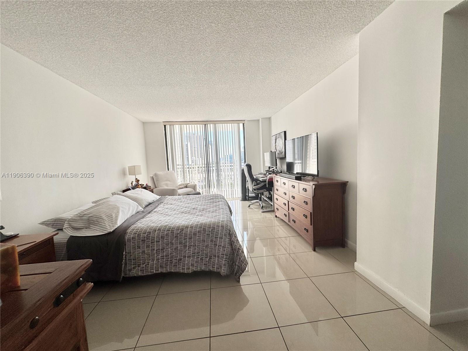 210 174th Street, Unit 1002 Sunny Isles Beach, FL 33160 - Photo 21 of 34 a bedroom with a bed and a dresser