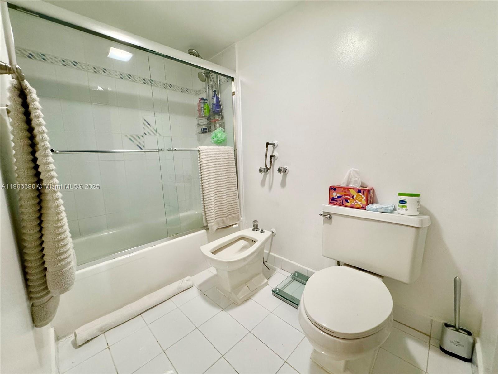 210 174th Street, Unit 1002 Sunny Isles Beach, FL 33160 - Photo 24 of 34 a white toilet sitting next to a bath tub and a shower