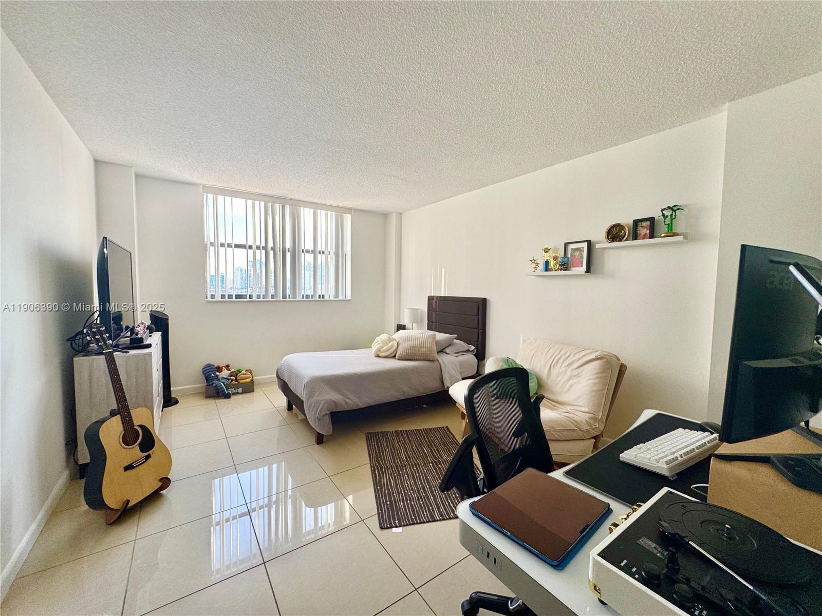 210 174th Street, Unit 1002 Sunny Isles Beach, FL 33160 - Photo 25 of 34 a living room with furniture and a flat screen tv