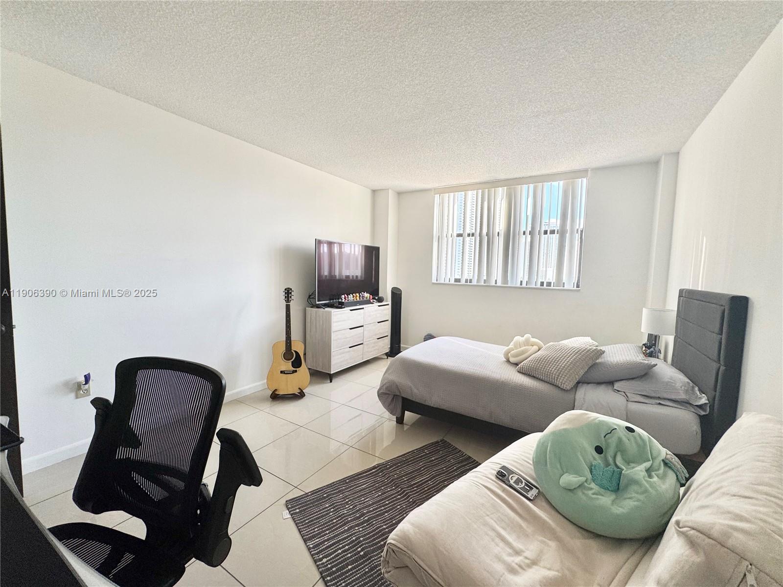 210 174th Street, Unit 1002 Sunny Isles Beach, FL 33160 - Photo 26 of 34 a living room with furniture rug and window