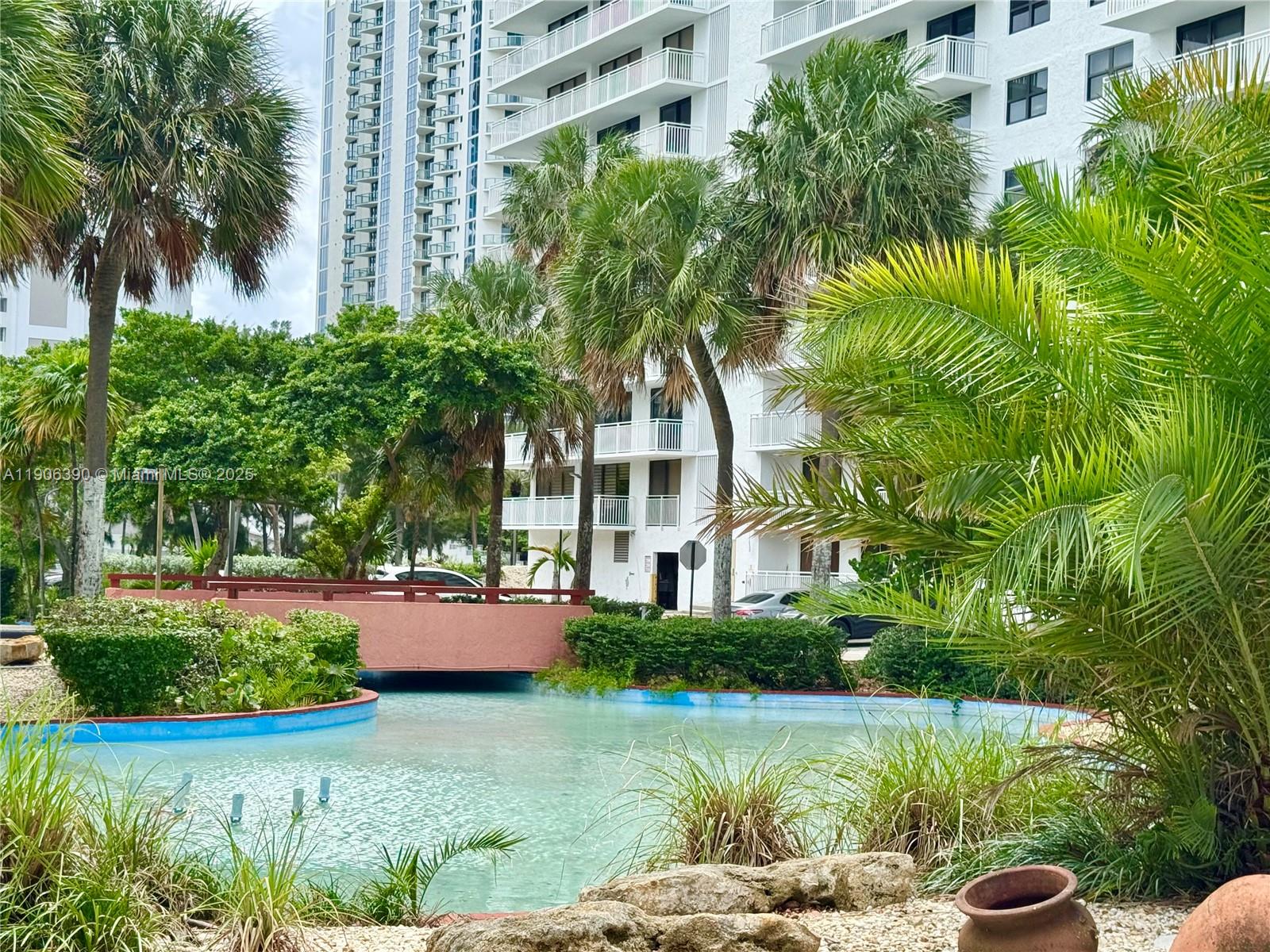 210 174th Street, Unit 1002 Sunny Isles Beach, FL 33160 - Photo 31 of 34 a front view of a house with garden