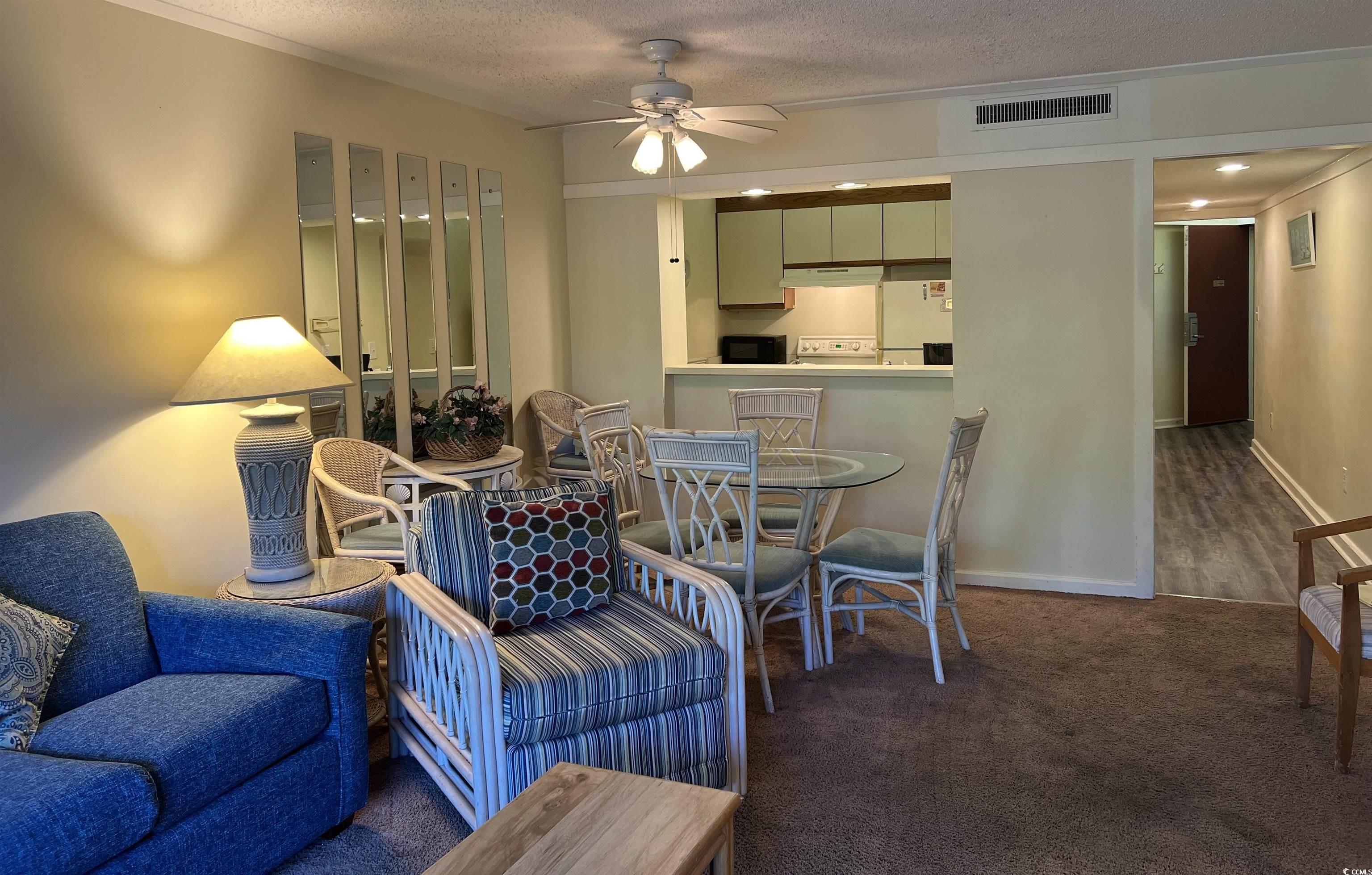 415 Ocean Creek Drive, Unit 2188 Myrtle Beach, SC 29572 - Photo 10 of 28 Living area with a textured ceiling, dark colored carpet, and ceiling fan