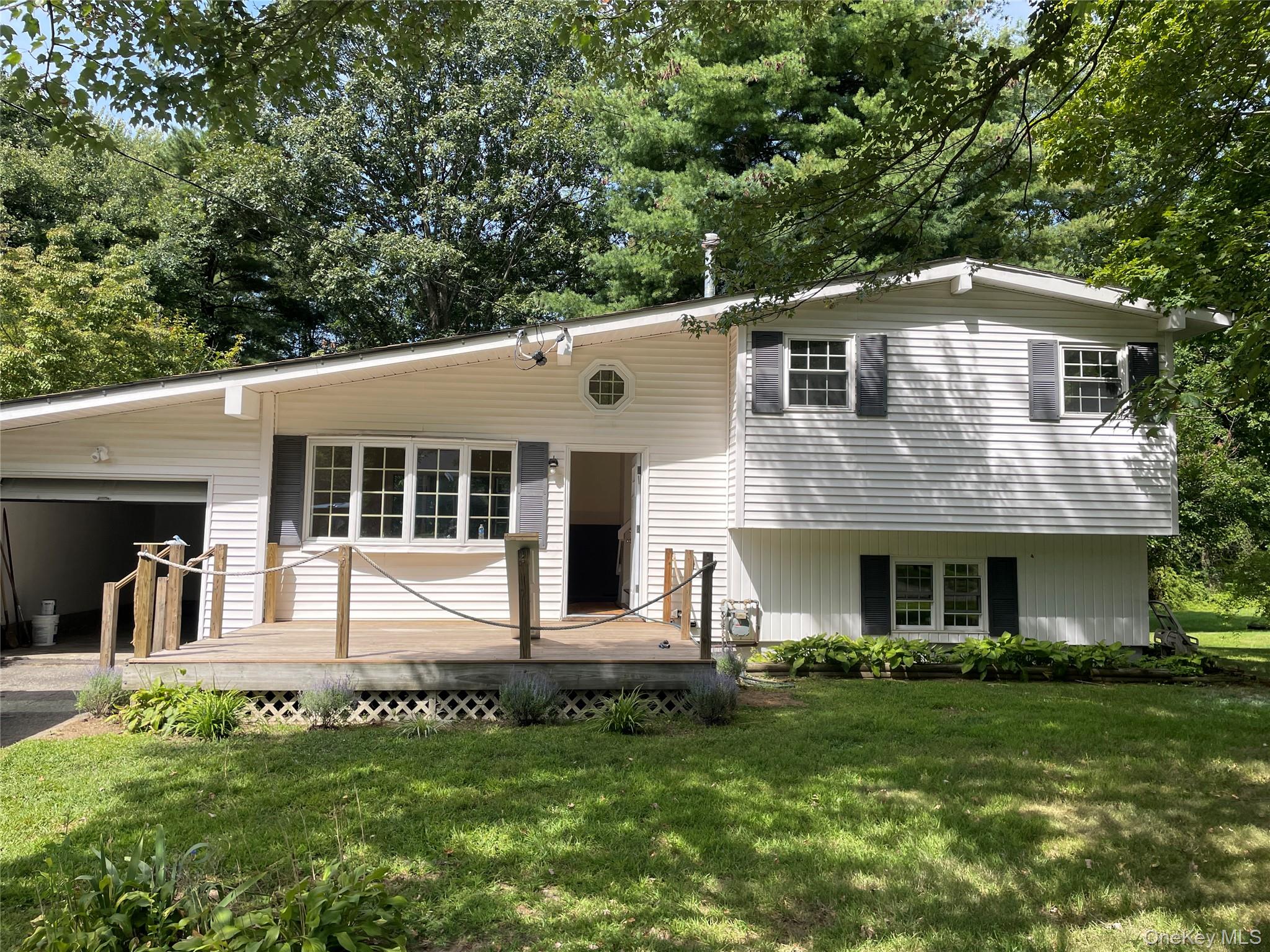 12 Ronsue Drive Wappingers Falls, NY 12590 - Photo 1 of 1 View of front of property with an attached garage, a front lawn, and a wooden deck