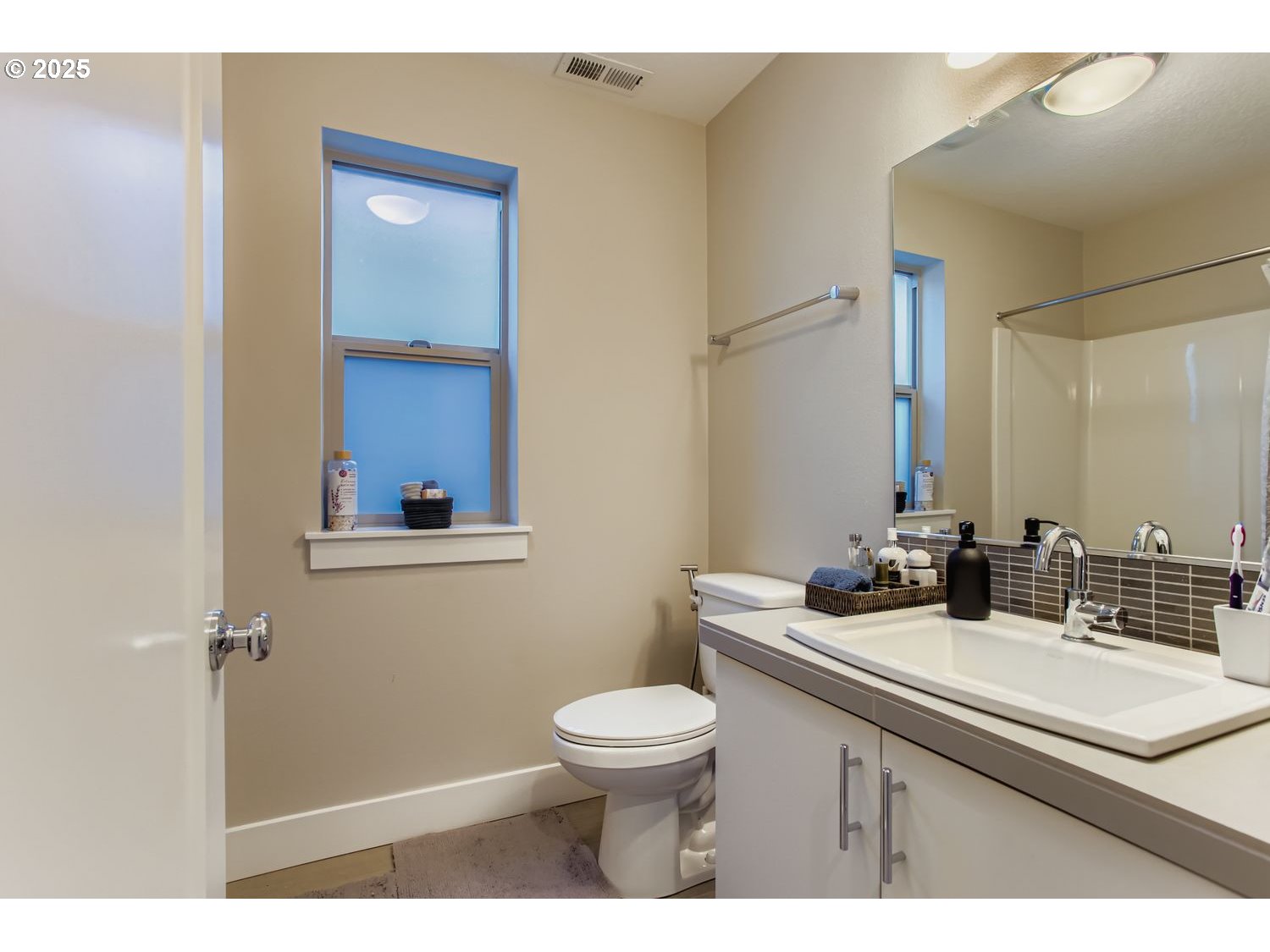 12119 Southwest Tesla Terrace Beaverton, OR 97008 - Photo 17 of 31 a bathroom with a sink toilet a mirror and vanity