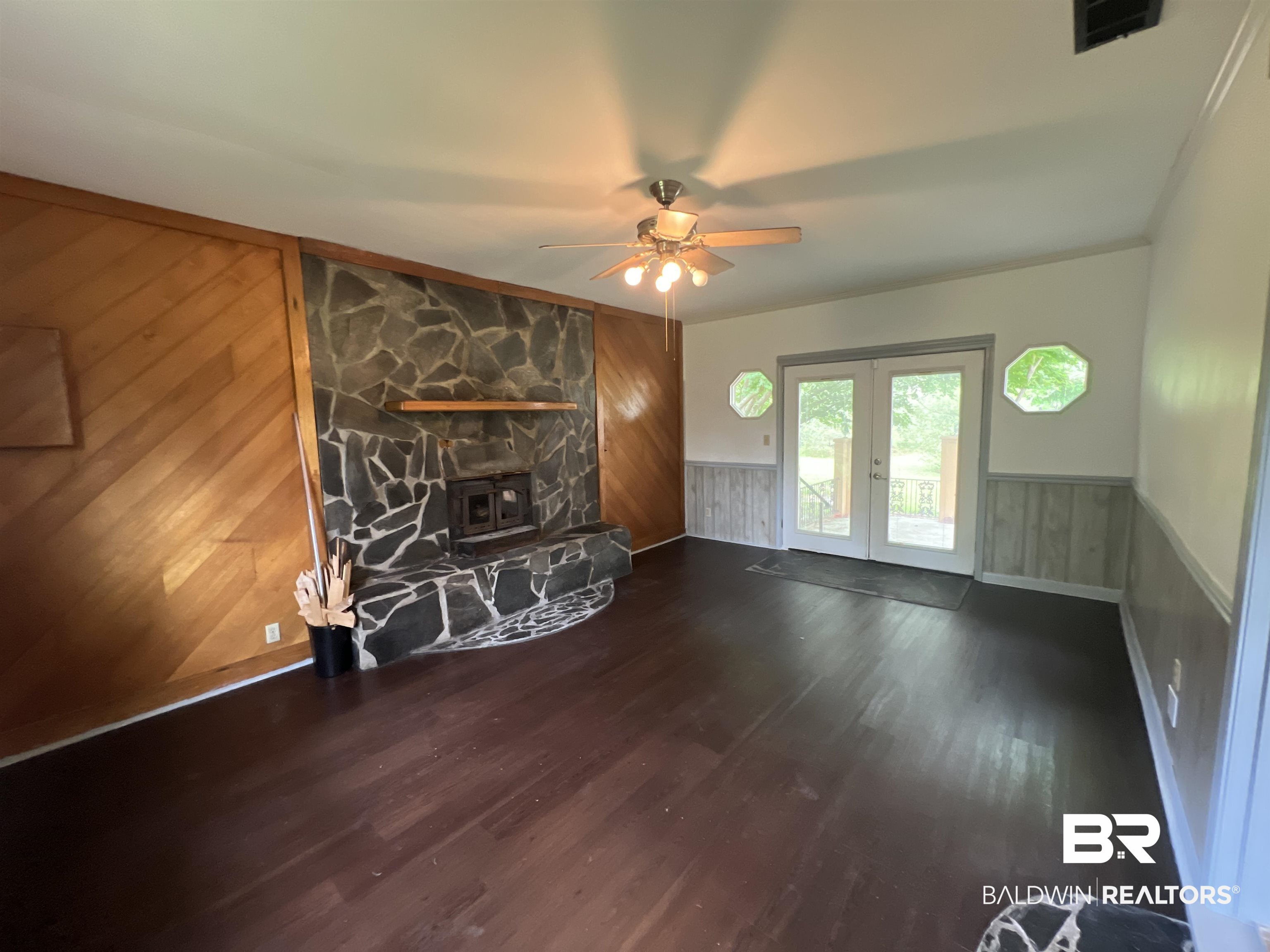 13301 A Hugh Fort Road Grand Bay, AL 36541 - Photo 16 of 34 Unfurnished living room with french doors, wood finished floors, a ceiling fan, a wainscoted wall, and wood walls