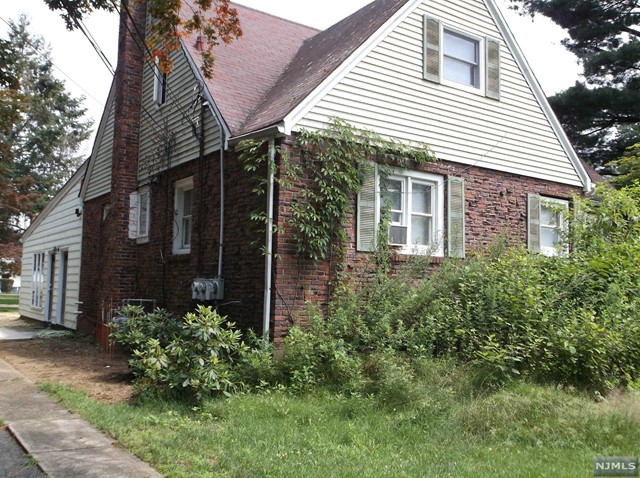 a view of a house with brick walls and a yard with plants