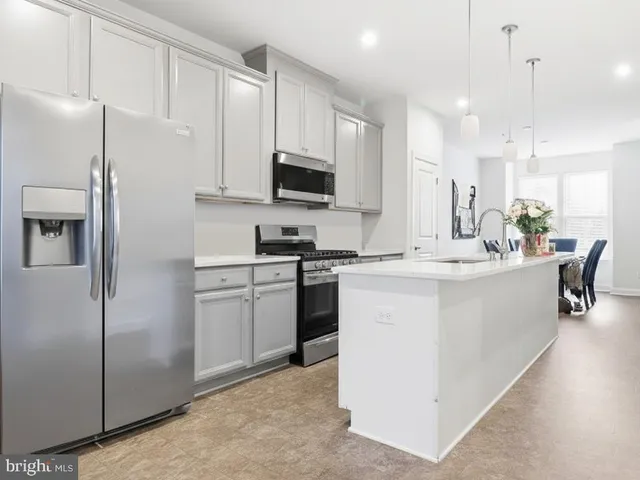 a kitchen with a refrigerator a sink and cabinets