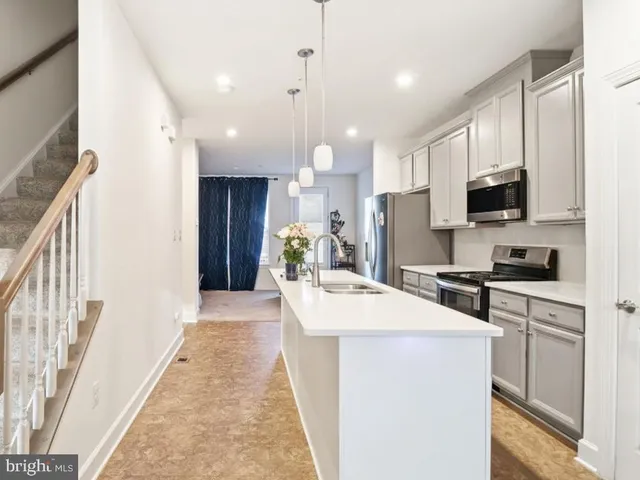 a kitchen with kitchen island a sink stainless steel appliances and cabinets