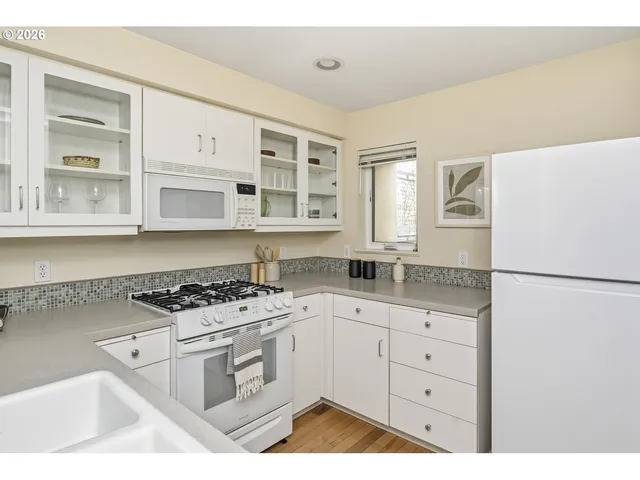 a kitchen with white cabinets and white appliances