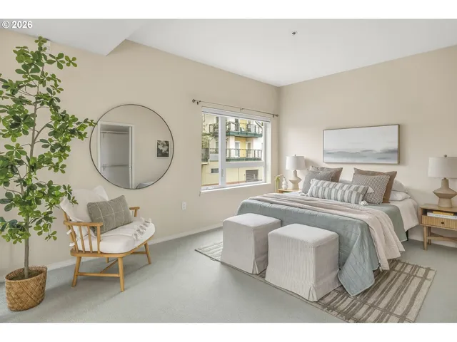 a bedroom with a bed a mirror and a potted plant