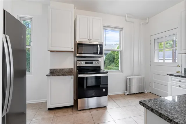 a kitchen with white cabinets and stainless steel appliances