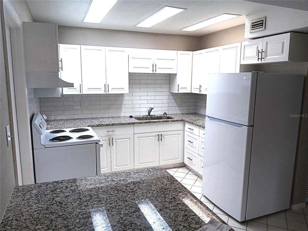 3756 Amherst Way, Unit 1 Sarasota, FL 34232 - Photo 4 of 14 a kitchen with a refrigerator and a sink