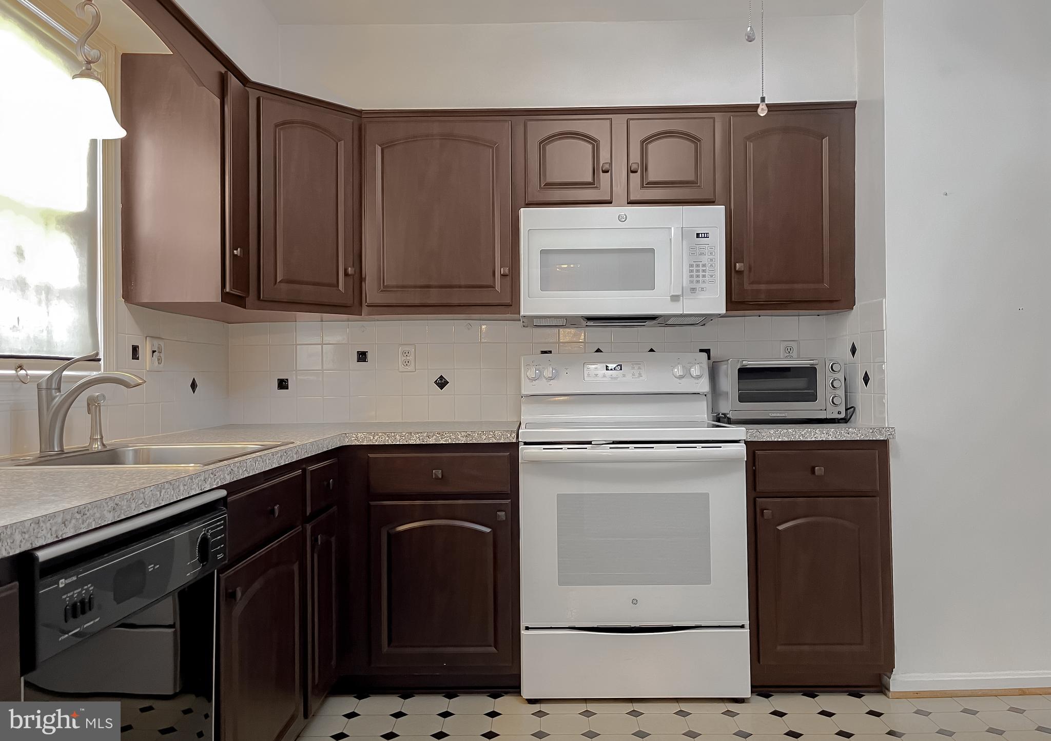 7004 Vismanco Lane Clinton, MD 20735 - Photo 16 of 63 a kitchen with a sink stove and microwave