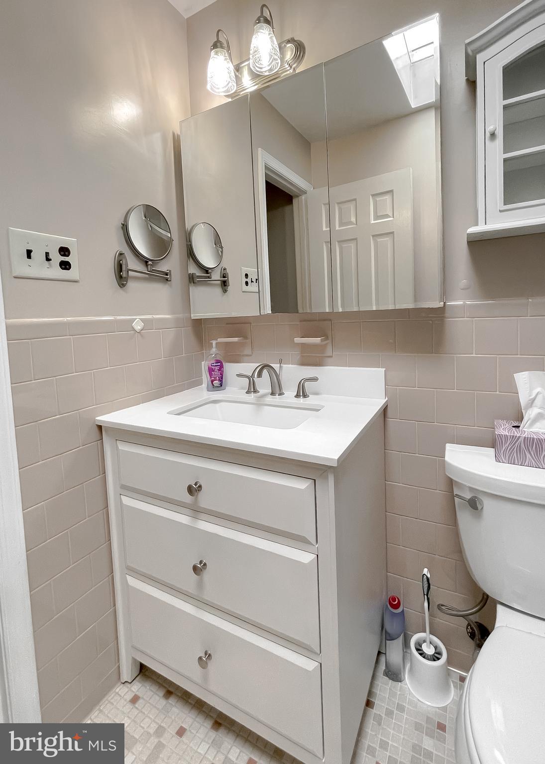 7004 Vismanco Lane Clinton, MD 20735 - Photo 27 of 63 a bathroom with a toilet a sink a mirror and vanity