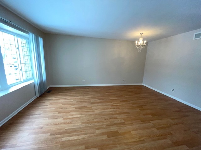 1267 Maroon Drive Elgin, IL 60120 - Photo 3 of 23 an empty room with wooden floor and windows