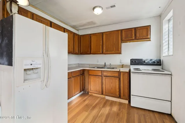 a kitchen with a refrigerator sink and cabinets