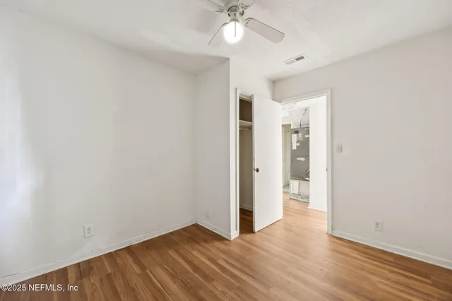 a view of an empty room with wooden floor