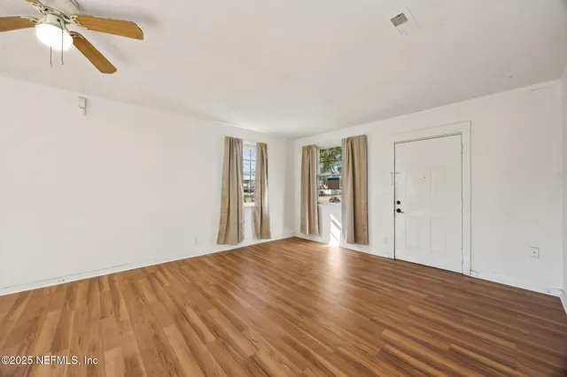 a view of an empty room with wooden floor